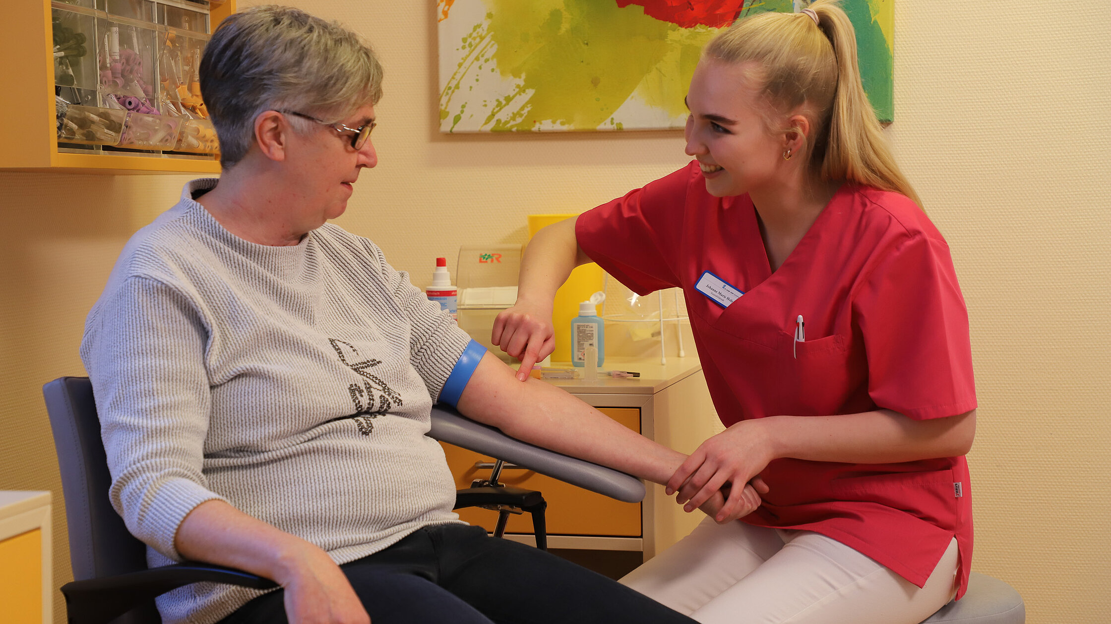 Medizinische Fachangestellte betreuen eine Patientin während einer Behandlung.