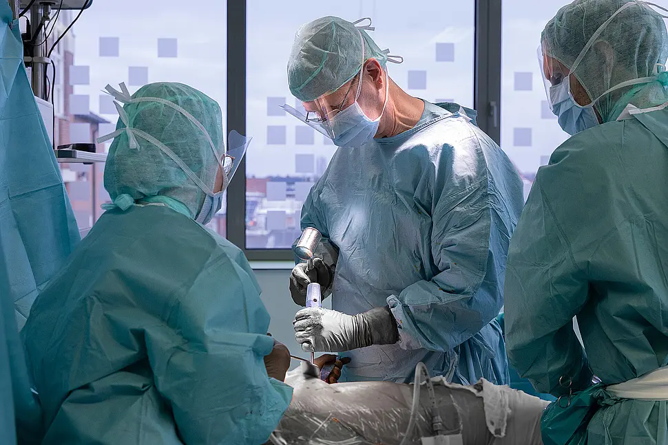 OP-Team kontrolliert Sitz und Ausrichtung der eingesetzten Hüftprothese.