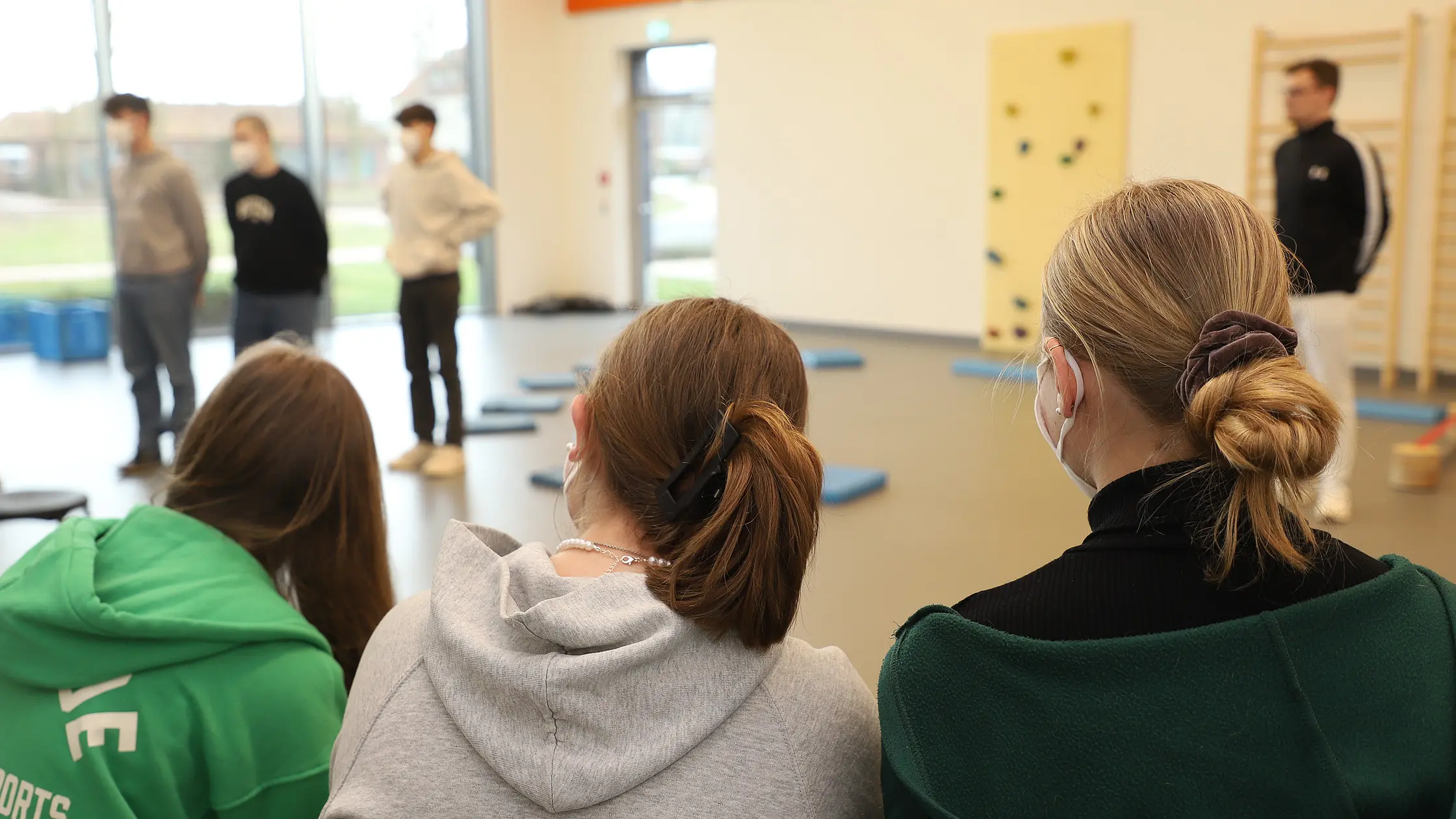 Schülerinnen und Schüler beobachten eine Übungseinheit in einer Therapieräumlichkeit.