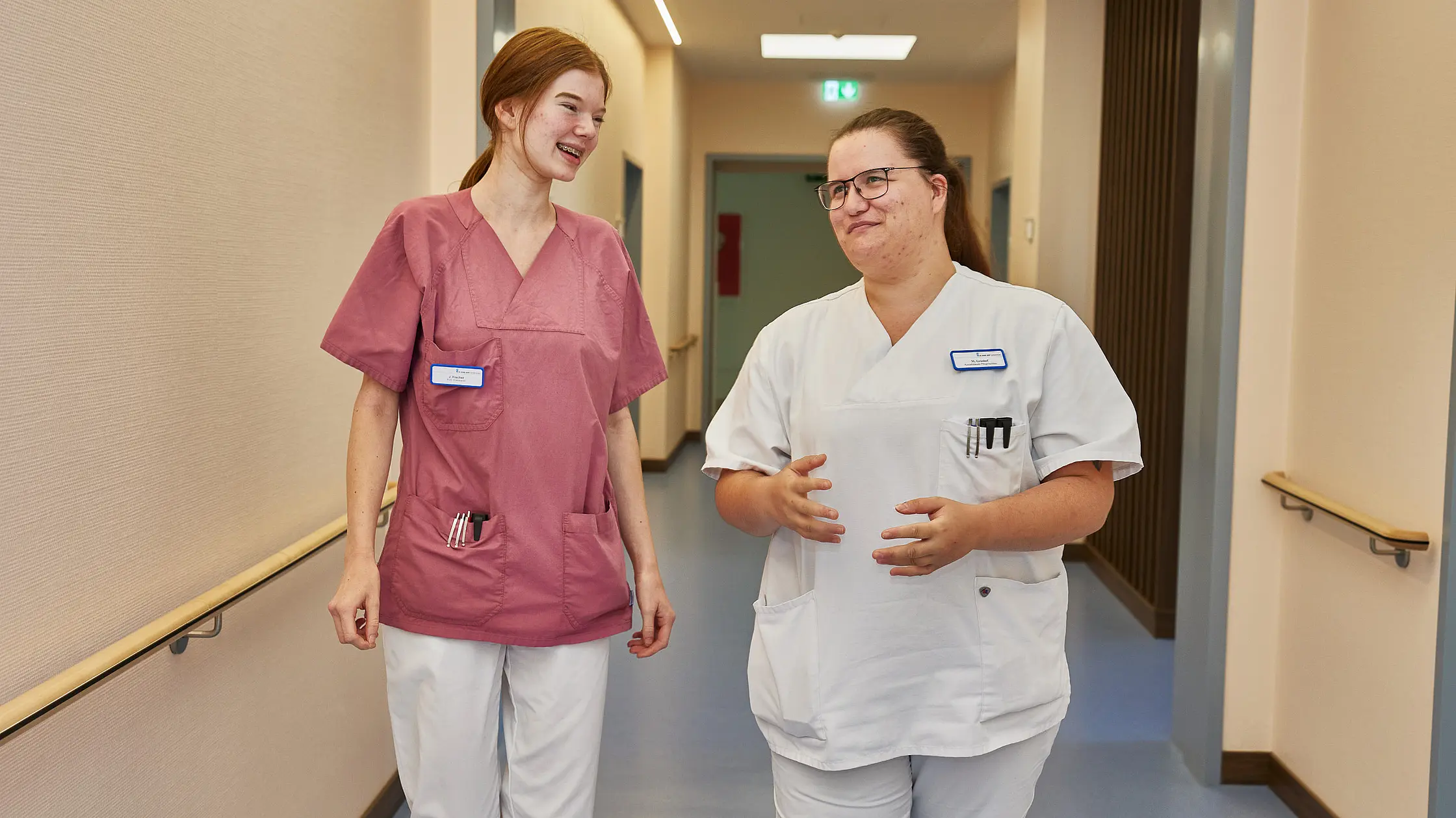 Zwei Mitarbeitende der Pflegefachassistenz im Austausch auf dem Stationsflur.