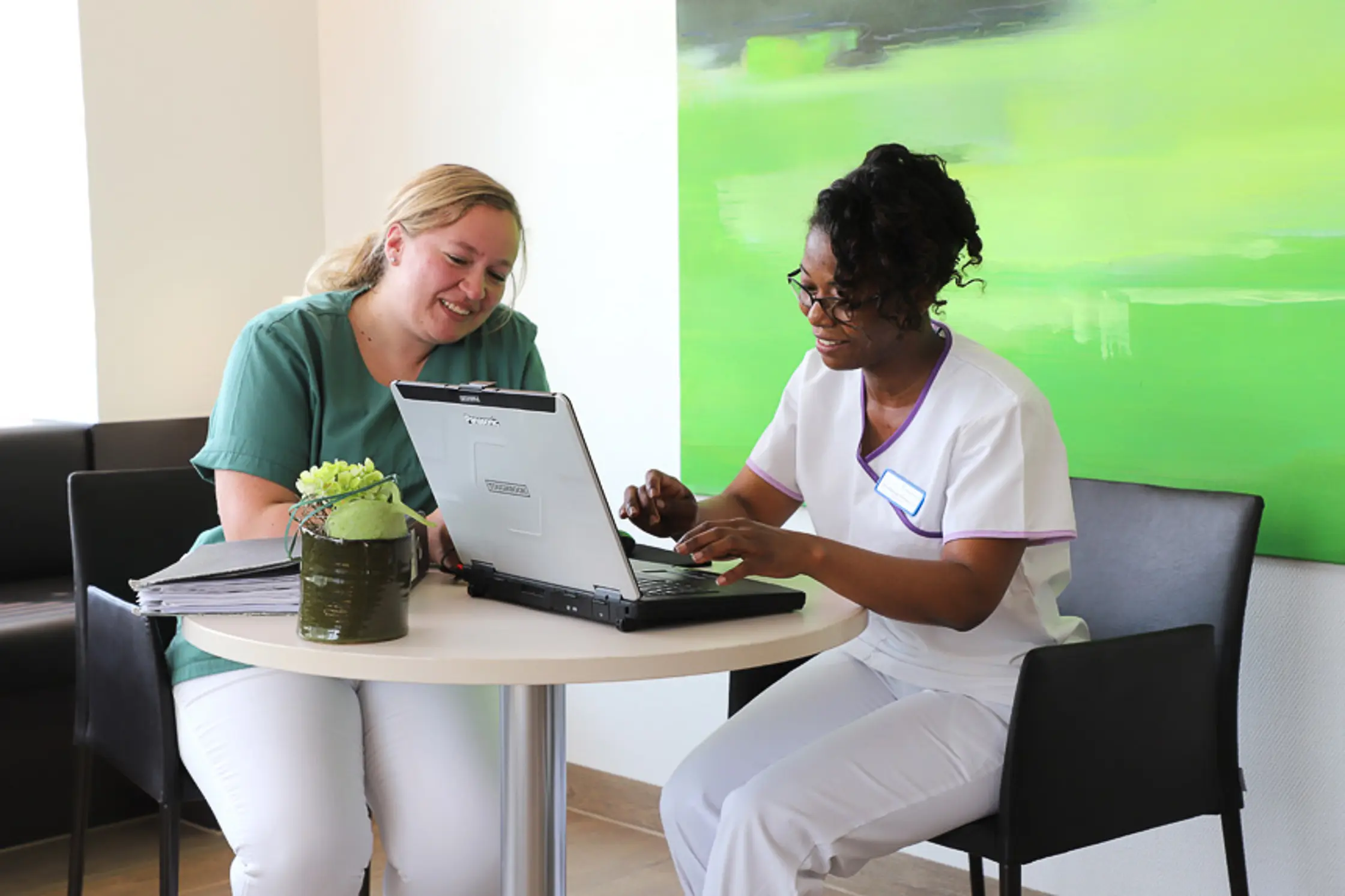 Praxisanleitung in der Krankenpflege: Pflegefachkraft begleitet Auszubildende im Patientenzimmer.