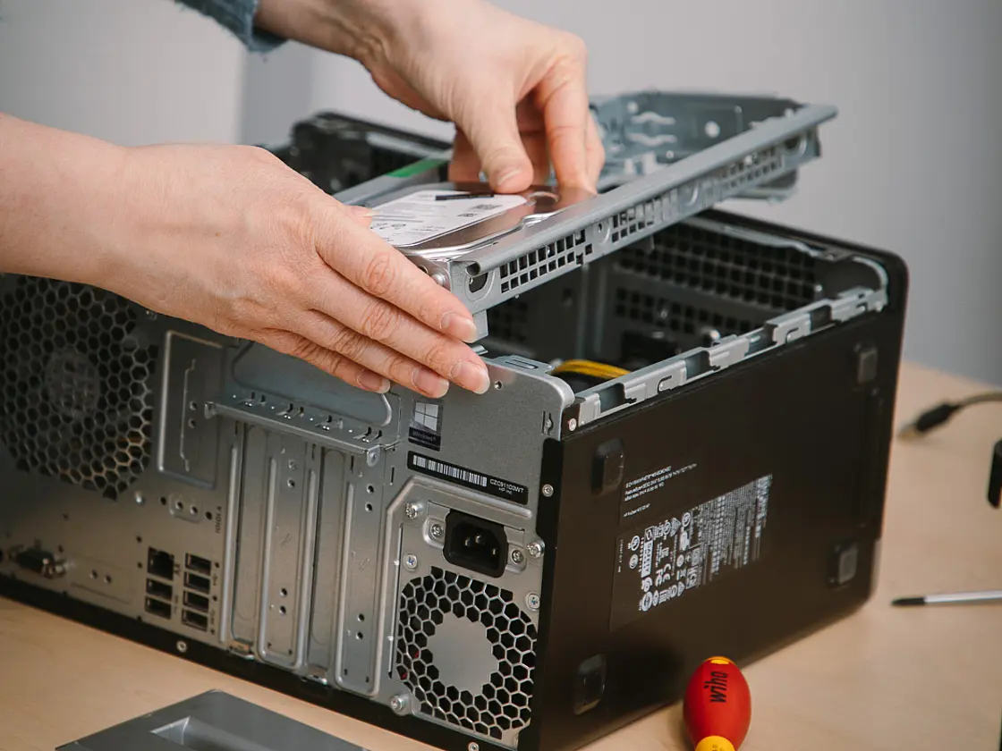 nblick in eine technische Ausbildung: Person baut Computerkomponenten in ein Gehäuse ein.