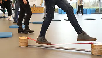 Schüler balancieren auf einem Trainingsgerät und testen ihre Geschicklichkeit.