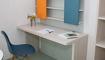 Arbeitsplatz mit Regal, Schreibtisch und dekorativer Blumenvase im Apartment.