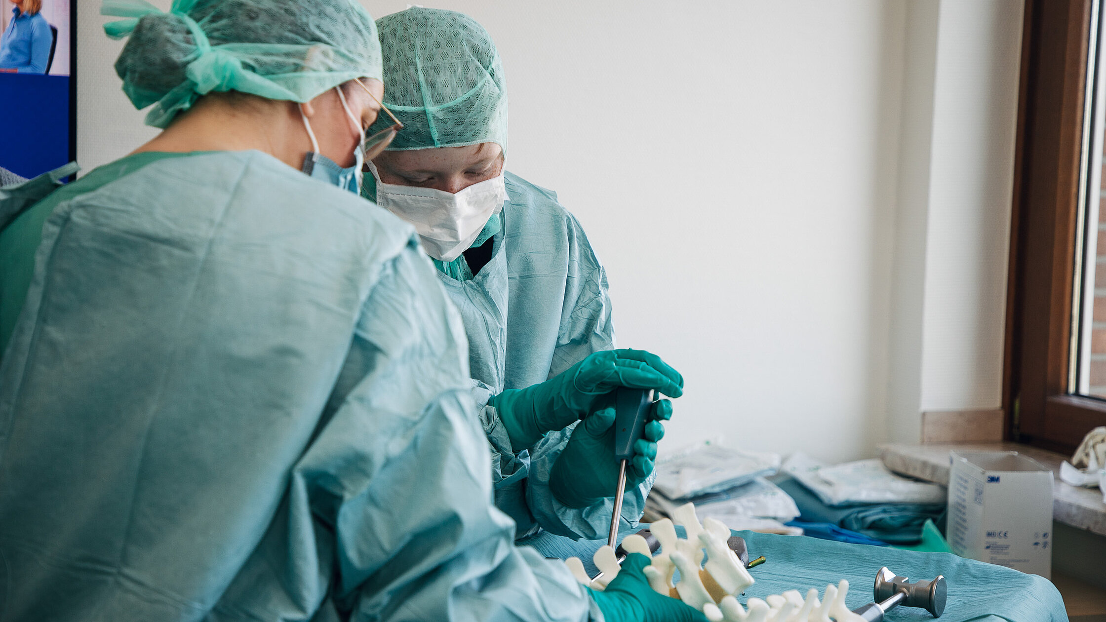 OP-Team arbeitet an einem Übungsmodell und erklärt medizinische Instrumente.