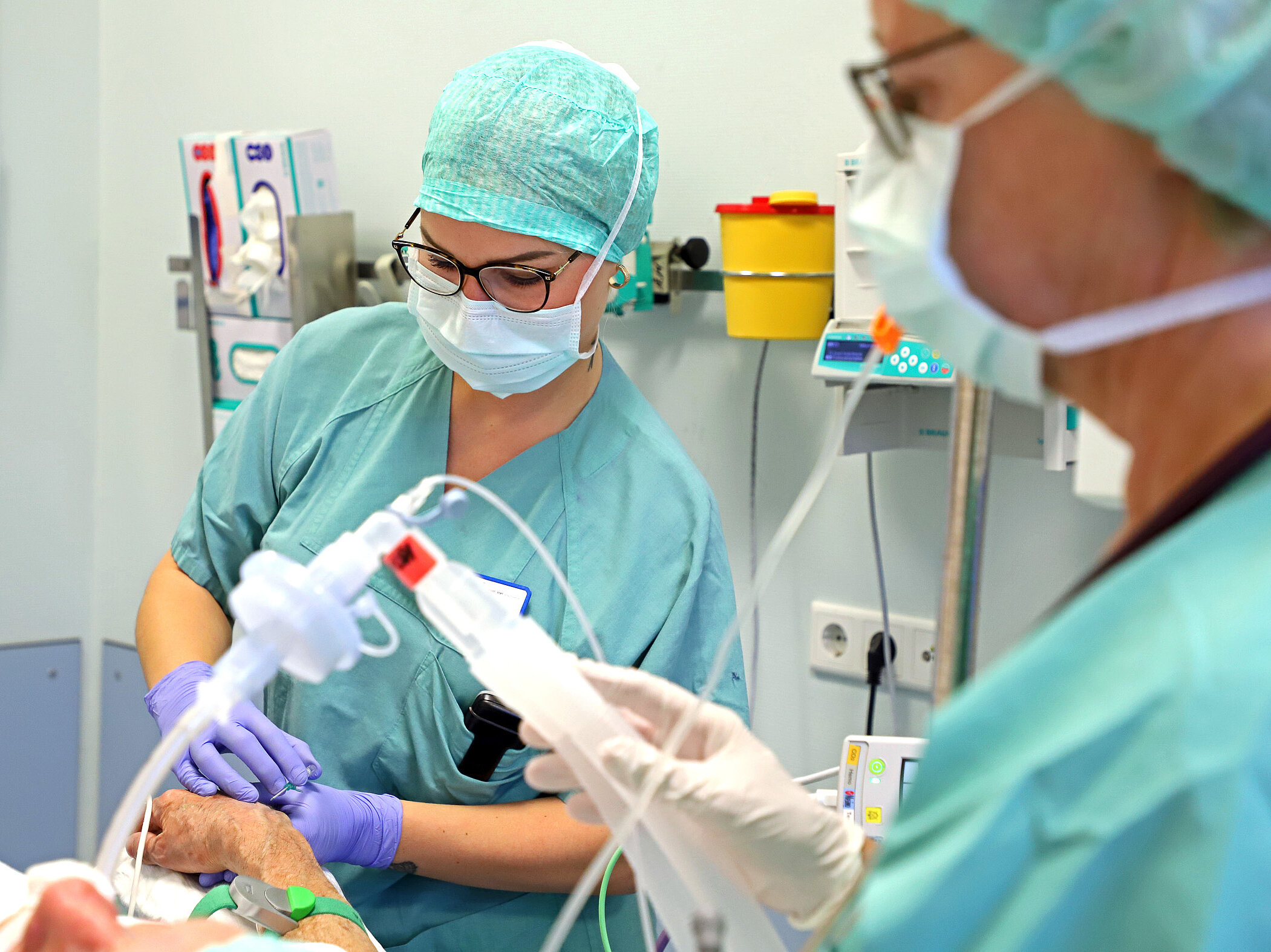 Ausbildung in der Anästhesiepflege: Pflegefachkräfte arbeiten gemeinsam bei der Versorgung eines Patienten im OP.