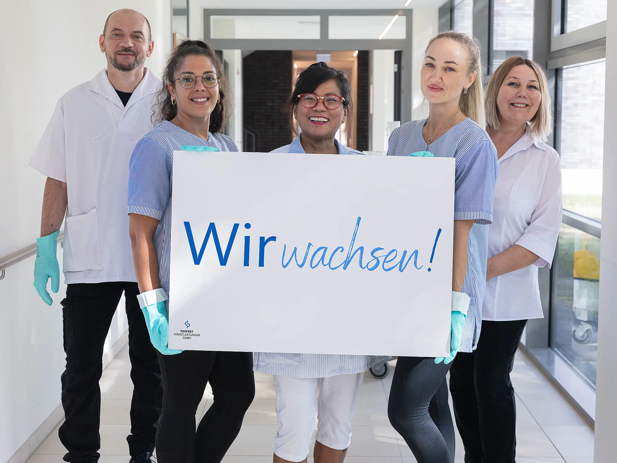 Ein Foto von fünf Menschen mit einem Schild in der Hand.